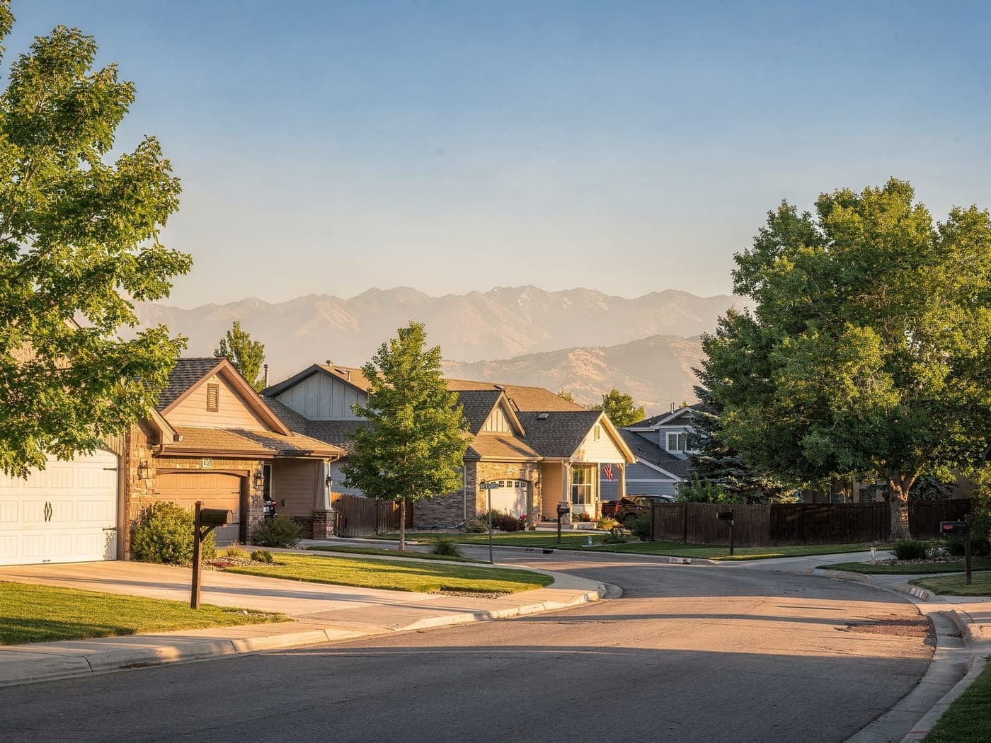 A quiet Highlands Ranch residential street with shingle-roofed homes and the Front Range foothills behind